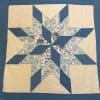Blue and cream patchwork quilt with a star pattern