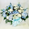 Blue hydrangeas and white chrysanthemums in a vase with a pale blue ribbon