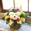 White teddy bear floral basket with colorful flowers and a red bow