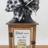 A rustic wooden lantern with a black metal roof and a bold