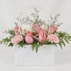 Soft pink roses and delicate pink-and-white carnations are arranged like a chic