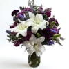 White lilies take center stage in this sympathy-leaning flower arrangement, making it