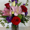 Bouquet of red roses and pink lilies in a glass vase