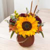 Embrace the cozy charm of fall with this stunning arrangement, artfully displayed