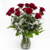 Red roses in a clear glass vase with white baby's breath