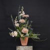 Tall pastel floral arrangement in a terracotta vase