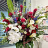 Large mixed bouquet with white orchids, red roses, and calla lilies in a vase