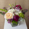 Mixed bouquet in a square glass vase with peach, white, and magenta blooms