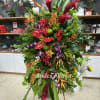 Large tropical floral standing spray with red, orange, purple, and green blooms