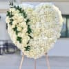 Heart-shaped white floral arrangement with cream roses and greenery