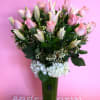 Pink roses and white lilies in a tall green vase