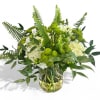 Green and white floral arrangement in a glass vase