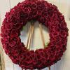 Large circular wreath of red roses on a wooden easel