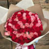 Large bouquet of red and pink roses wrapped in brown paper