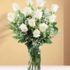 White roses in a clear glass vase with baby's breath