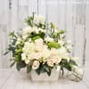 White and blush floral arrangement in a rectangular vase with calla lilies and roses
