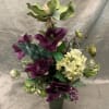 Purple and cream floral arrangement in a dark vase