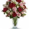 Bouquet of red, pink, and white roses in a clear glass vase