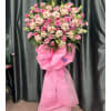 Pink and white floral standing spray with a large pink bow