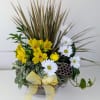 Yellow and white flowers arranged in a low bowl with a ribbon