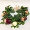 Floral wreath with peach and burgundy blooms and a sheer ribbon bow