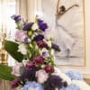Tall floral arrangement with blue hydrangeas, purple lisianthus, and pink carnations