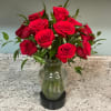 Red roses arranged in a clear glass vase
