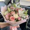 Pink and white bouquet with roses, lilies, and gerbera daisies wrapped in pastel paper