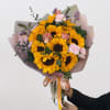 Handheld bouquet of sunflowers, pink roses, and carnations wrapped in pastel paper
