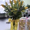 Yellow tulips in a clear glass vase with a yellow ribbon