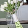 White tulip bouquet with small pink filler flowers and a matching boutonniere