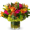 Bright mixed bouquet of roses and lilies in a glass vase