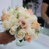 A classic bridal bouquet of roses white and peach hand-tied with ribbon