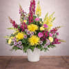 Colorful mixed flower arrangement in a white pot