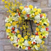 Yellow and white floral wreath on a black stand