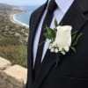White rose boutonniere on a black suit jacket