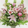 Pink lilies and roses in a clear vase