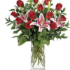 Tall vase filled with lovely double lilies and red roses.