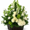 White roses and green flowers arranged in a wicker basket