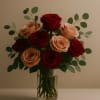 Bouquet of red and blush roses in a clear glass vase