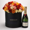 Box of multicolored roses beside a champagne bottle