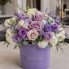 Lavender, blush, and white roses arranged with white hydrangeas and purple lisianthus