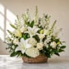 White lilies and roses arranged in a wicker basket