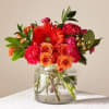 Bouquet of red and orange flowers in a clear glass vase