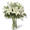 A serene and elegant arrangement of white lilies, accented with delicate greenery.