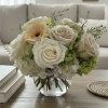 A soft, rounded arrangement of white and green hydrangea, 6 light-colored roses