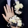 White rose boutonniere and wrist corsage on a suit and wrist