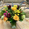 Mixed bouquet of yellow and orange roses in a clear glass vase