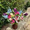 Mixed bouquet in a textured vase with pink roses and lilies