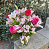 Bouquet of pink roses and lilies in a clear glass vase